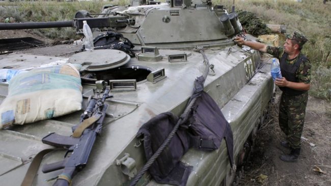 A Ukrainian soldier cleans his armored personnel carrier near Donetsk in eastern Ukraine Monday. Russia says a large convoy that's heading to the area from Moscow is carrying humanitarian aid. Anatolii Stepanov/AFP/Getty Images
