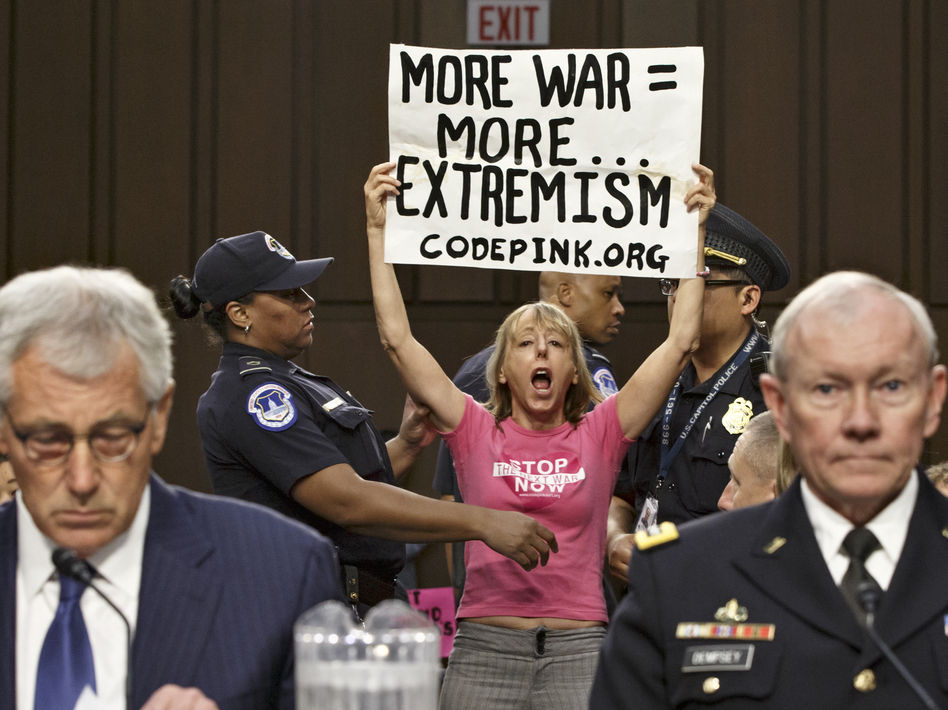 Members of the anti-war activist group CodePink interrupt a Senate Armed Services Committee hearing with Defense Secretary Chuck Hagel (left) and Gen. Martin Dempsey, chairman of the Joint Chiefs of Staff. J. Scott Applewhite/AP