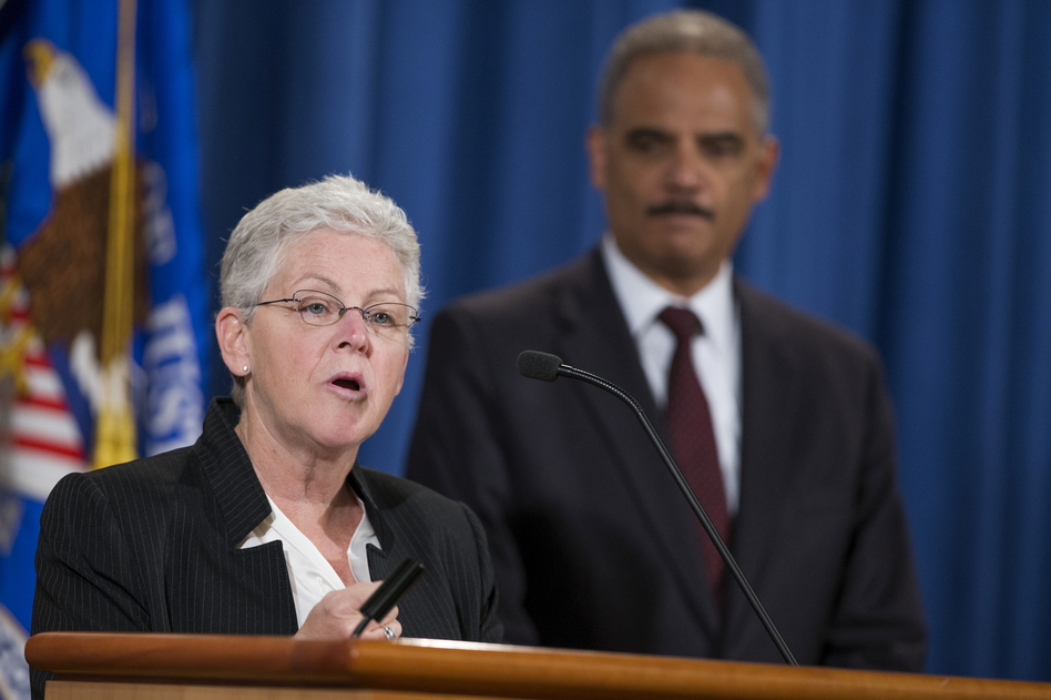 Attorney General Eric Holder listens at right as Environmental Protection Agency Administrator Gina McCarthy speaks during a news conference at the Justice Department in Washington on Monday. Evan Vucci/AP