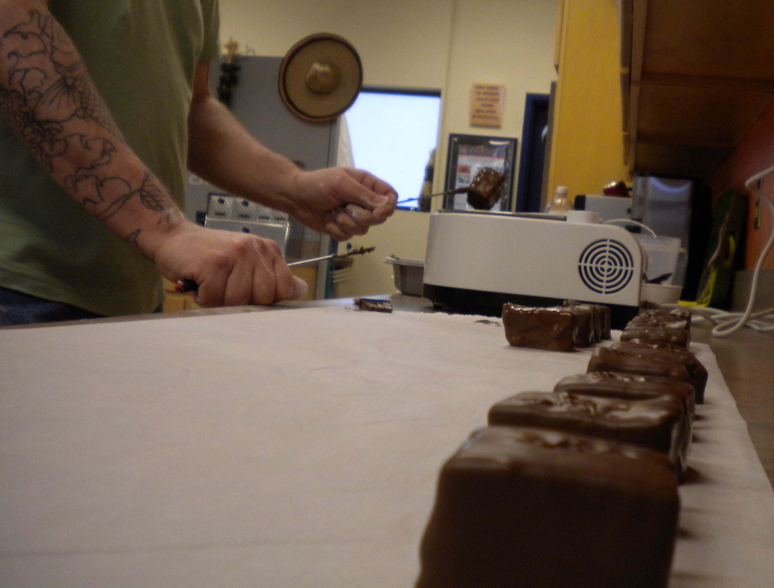 Jason Puckett coats his homemade marshmallows with chocolate he buys from Alaska Fudge Company. (Photo by Kevin Reagan / KTOO)