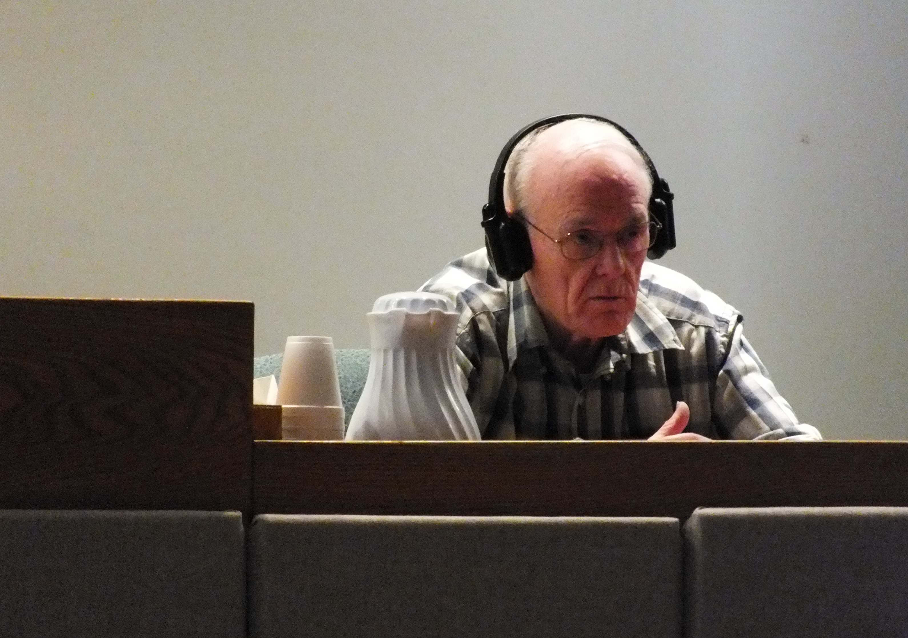 Rayco Sales owner Ray Coxe wears a set of hearing-assist headphones as he listens to a question in Juneau Superior Court during his civil trial in June. (Photo by Matt Miller)