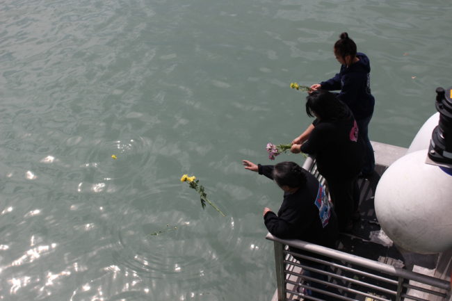 Family members aboard the Douglas Indian Association chartered cruise threw flowers into the water to honor deceased relatives. (Photo by Elizabeth Jenkins/KTOO)
