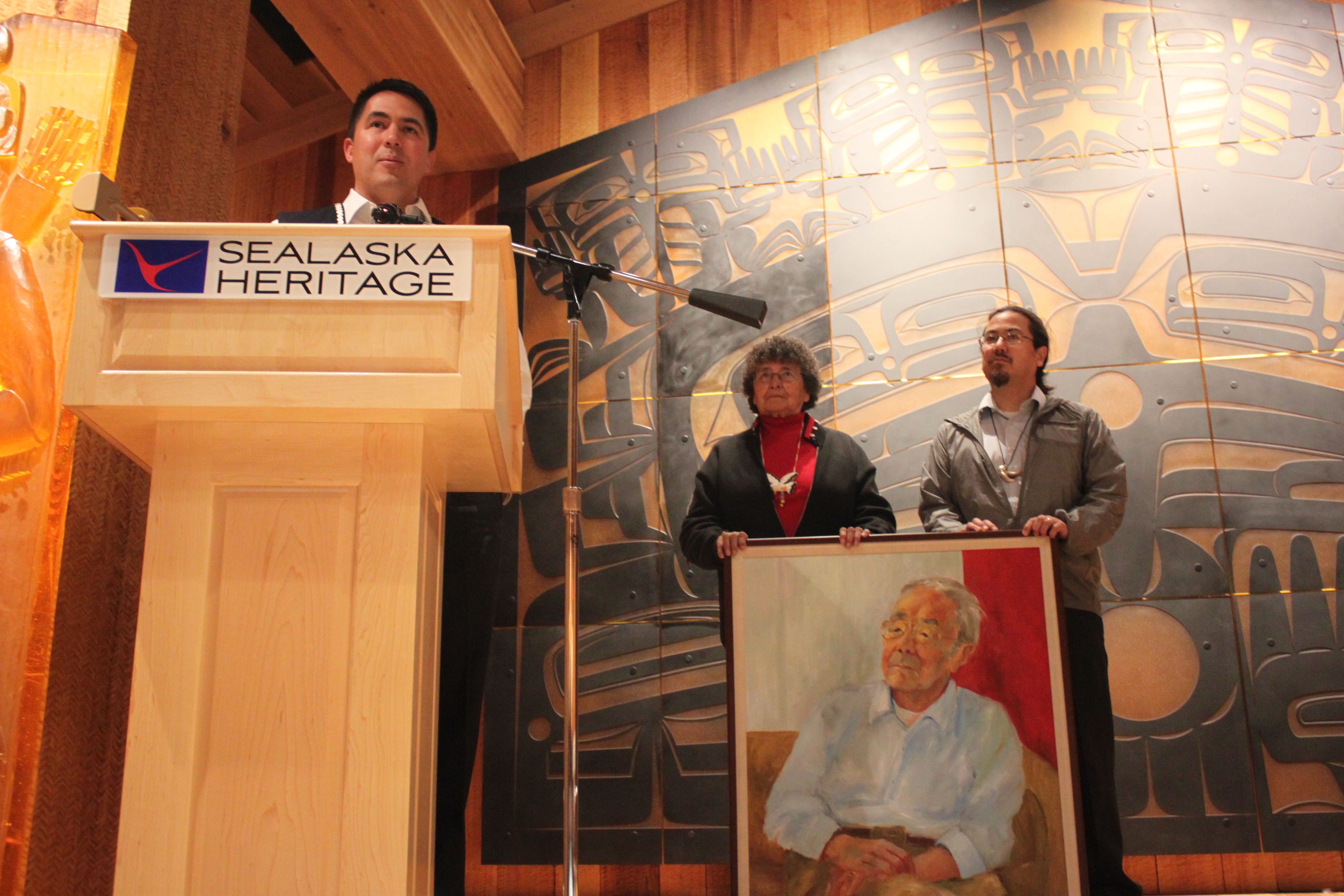 Sealaska Corporation CEO Anthony Mallott remembers Dr. Walter Soboleff. SHI board chair Marlene Johnson and Sealaska board chair Joe Nelson stand by a portrait of Soboleff. (Photo by Lisa Phu/KTOO)