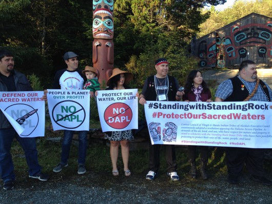 Protesters carry signs opposing the Dakota Access Pipeline. (Photo by KRBD)