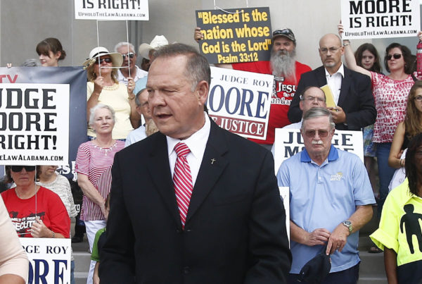 Alabama Chief Justice Roy Moore, seen here addressing the media in August, won't be paid for the rest of his term and must pay court costs. (Photo by Brynn Anderson/Associated Press)