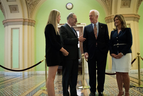 Sens. Chuck Schumer, D-N.Y., and John Cornyn, R-Texas, speak with Kaitlyn (left) and Terry Strada — whose husband, Thomas, died in the Sept. 11 attacks — after a May 17 news conference concerning the Justice Against Sponsors of Terrorism Act in Washington.