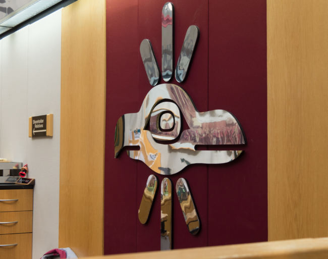 A Sealaska corporate logo is mounted behind the main receiptionsts desk at the Southeast Alaska Native corportation's headquarters in Juneau on May 2, 2018.