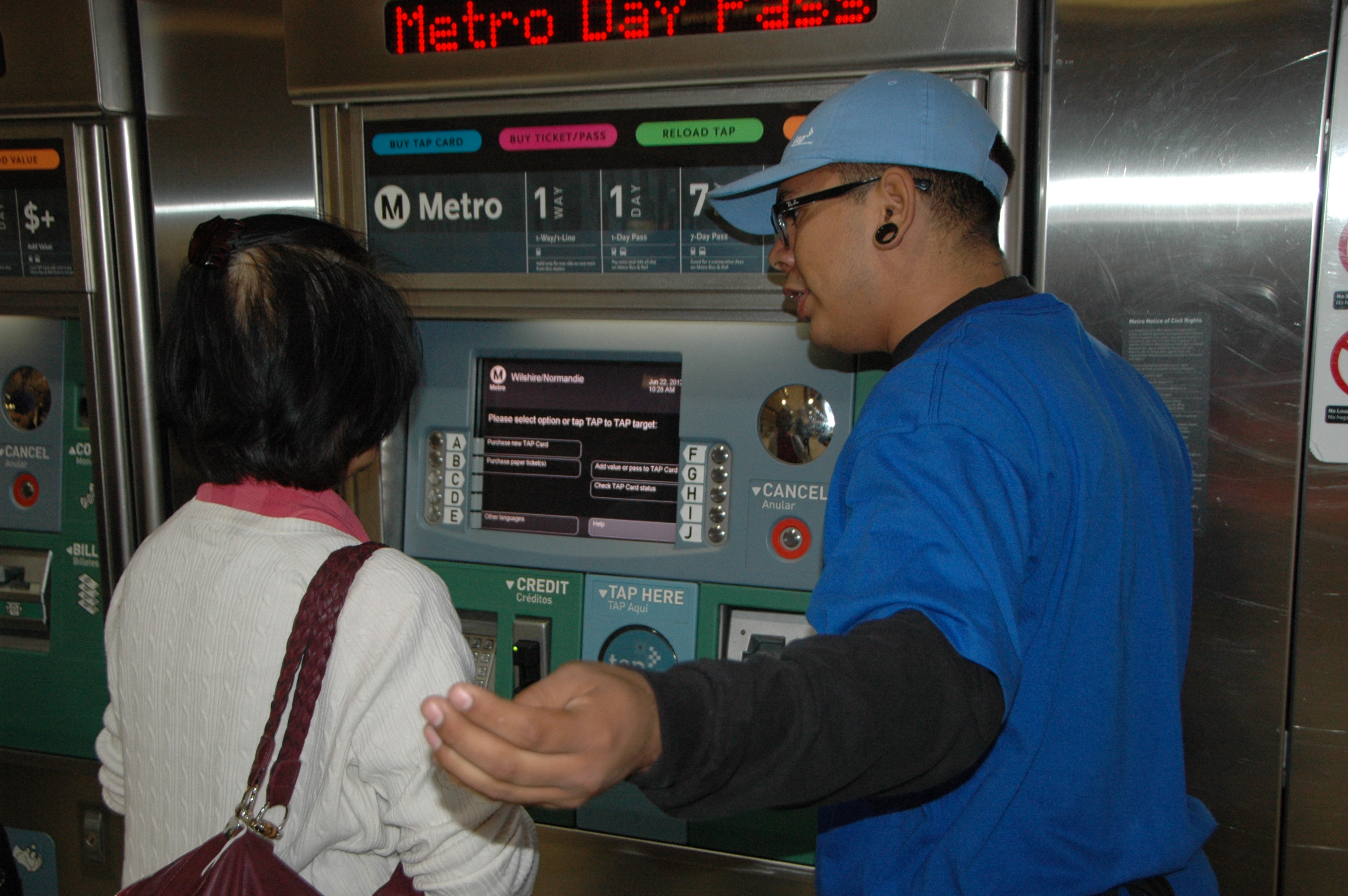 TAP Empleado de Metro ayuda a una persona a comprar la tarjeta TAP en la estación Normandie de la Línea Morada del Metro.