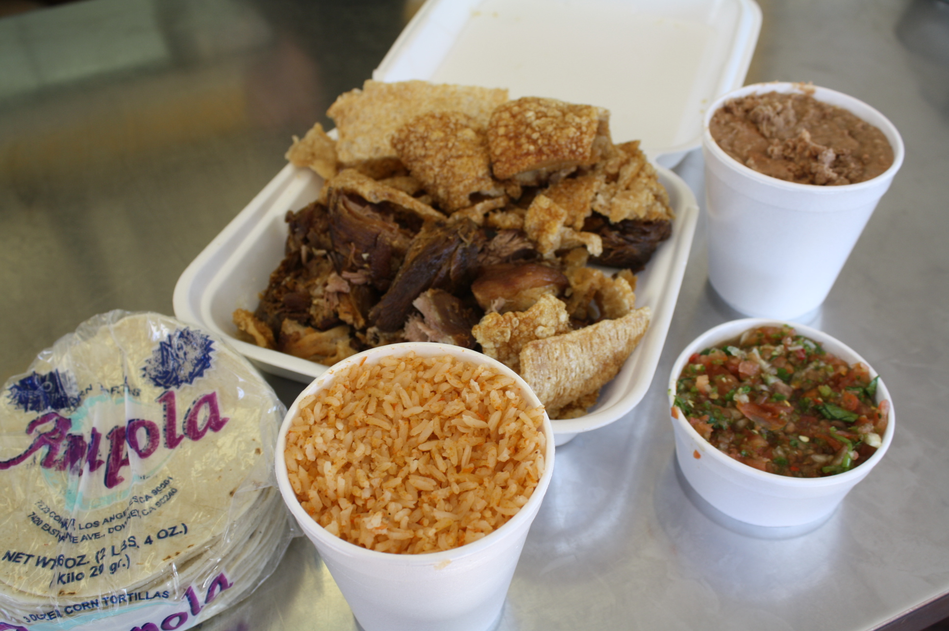 La Amapola El paquete familiar de carnitas es económico y muy llenador con su arroz rojo, salsa mexicana, frijoles refritos y tortillas. (Foto de Agustín Durán/El Pasajero).