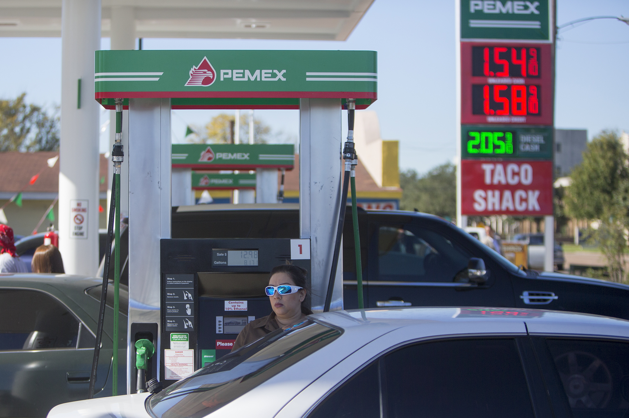 Yvette Garcia fills up with gas at the grand opening of PEMEX in the 7900 block of Park Place Blvd, Thursday, Dec. 3, 2015, in Houston. The national energy company of Mexico, Pemex, is launching its brand in the U.S. with retail gasoline stations, starting in Houston. (Cody Duty / Houston Chronicle)