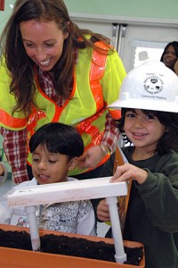 In the interest of safety, Kasey Shuda, Wilshire Segment Community Relations Officer, loans her hard hat to a young bridge engineer.