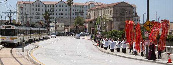 Procession on Flower Congregation of St. John's Cathedral in downtown Los Angeles keeps pace with approaching Expo train. Photo by Luis Inzunza.