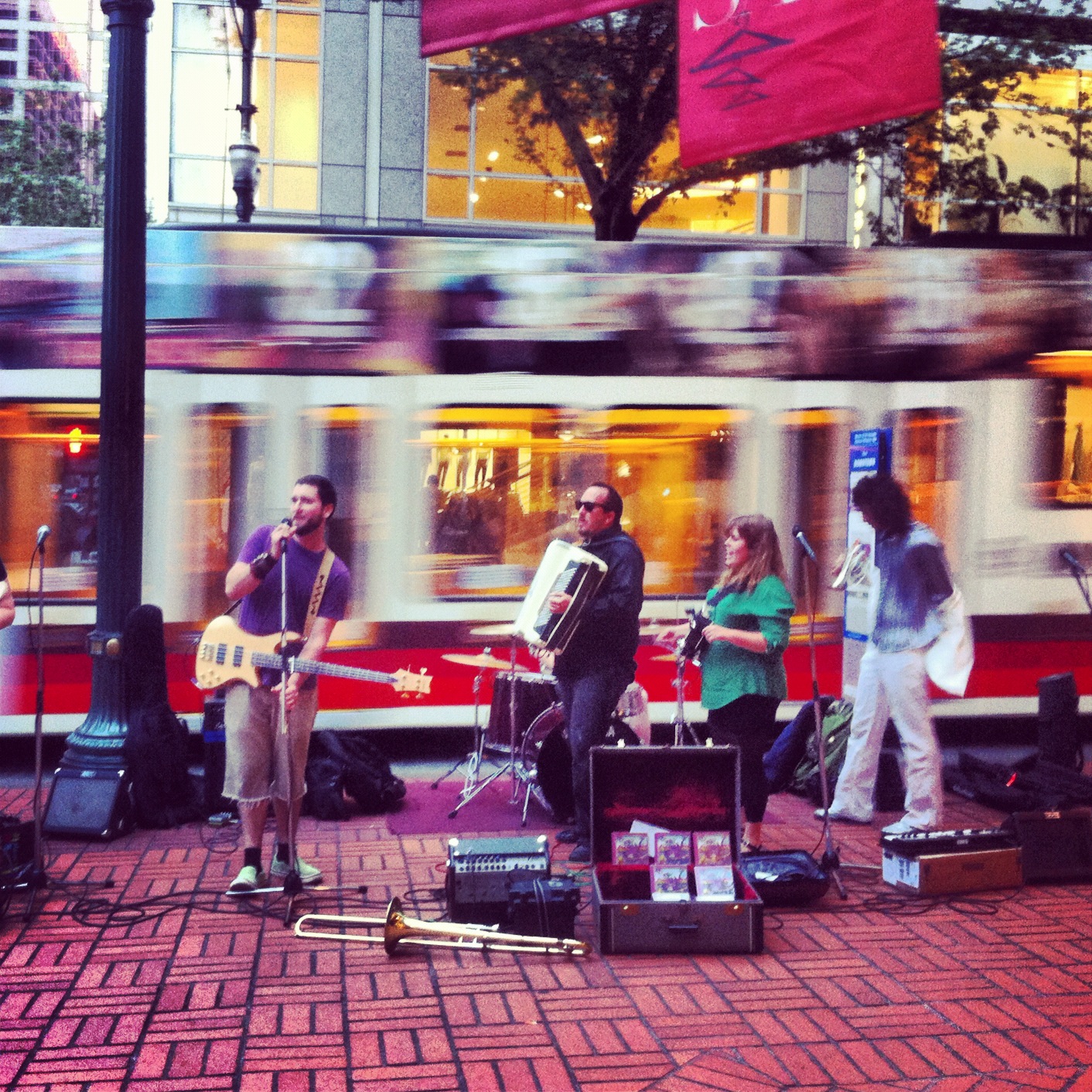 Portland street band plays in front of MAX train