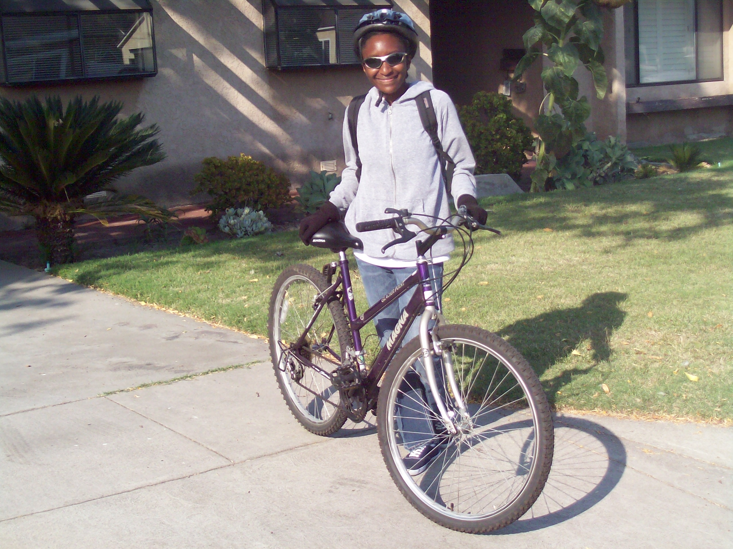 Breeanna with her mountain bike, helmet, and sunglasses getting ready to bike to work. Photo courtesy of Breeanna Taylor.
