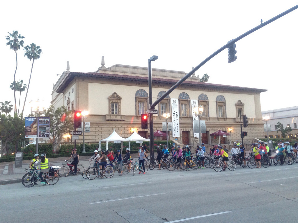 Maria guides several dozen bicyclists in front of the Pasadena Civic Auditorium.