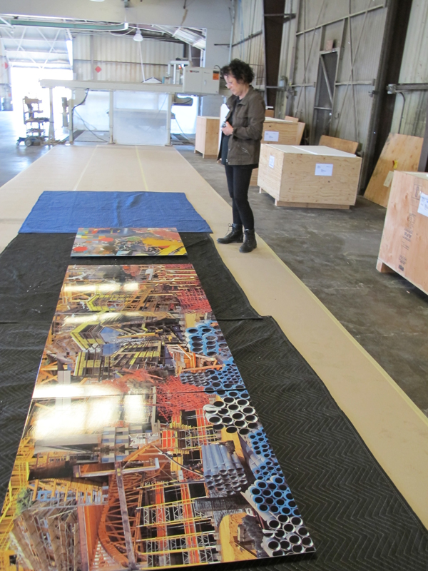Constance Mallinson inspecting one of her artwork panels after it was delivered by the fabricator to ensure that the colors of her original artwork are accurately reflected in porcelain enamel steel and that the color is consistent among all of the panels.