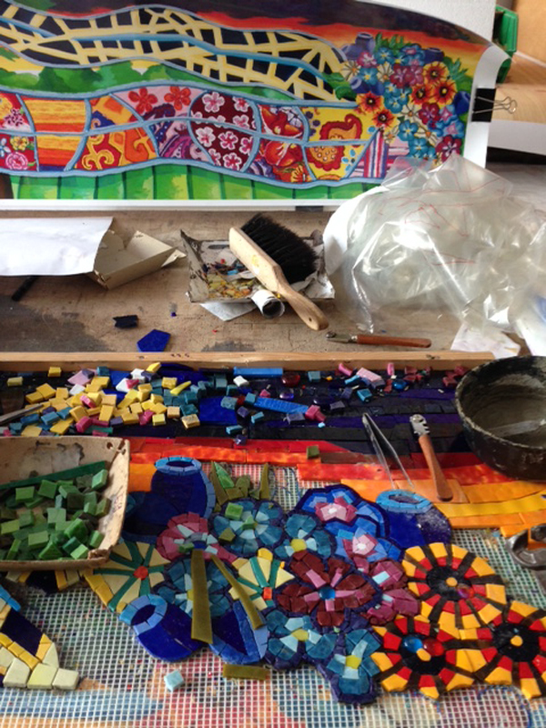 The two photos above show the assembly of thousands of glass mosaic pieces to match the artist's original mixed media paintings at the fabricator's shop. The high resolution scans of the original paintings are visible underneath a mesh base, onto which the mosaic pieces are adhered. Photo courtesy Mayer of Munich.