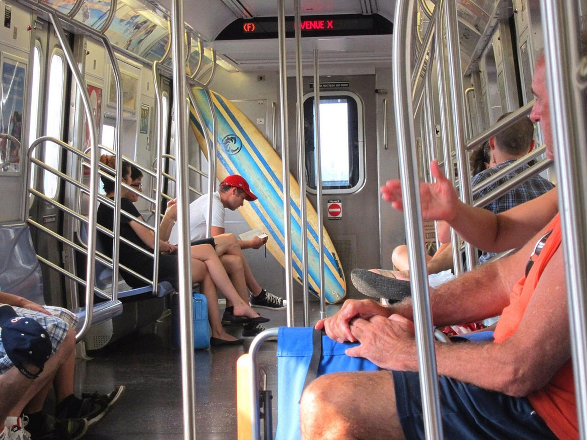 Surfing via the New York Subway, which serves the Atlantic Ocean via a long ride through Brooklyn. Photo by Carmen, via Flickr creative commons.