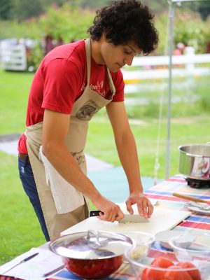 Robin Morgan chops onion in an outdoor kitchen.