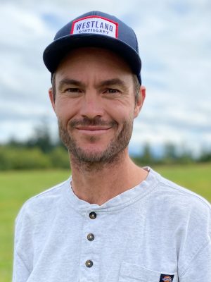Man with stubble and blue baseball cap.