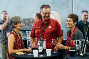guests of a previous private barrel auction stand around table tasting barrel samples.