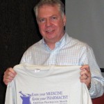 State senator Ed Murray holds up a UW School of Pharmacy T-shirt students gave to him during a tour of their school.