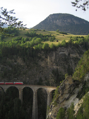 A train crosses a river gorge in the Swiss Alps that drops steeply from the floor of the broad glacial valley above it. (Credit: Oliver Korup)