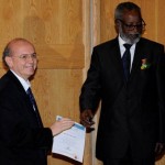 Sam Nujoma, University of Namibia chancellor, presents the UW a certificate of appreciation, accepted by Andy Stergachis, UW professor of epidemiology and global health and adjunct professor of pharmacy.