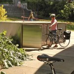A campus commuter stores her bike in one of the many bike lockers available for rent.