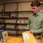 UW Libraries staffer Brent Waller packs a book to be sent to a faculty or staff member's campus mailbox under the new Departmental Delivery service.