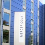 Sign saying Merce Court in front of blue building
