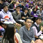 Man talks with two rows of students in class auditorium