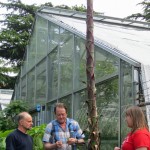 People gather around pot with plant that has tall flower spike