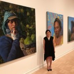 Artist Arely Morales with her three paintings depicting immigrant workers at the 2017 MFA + Mdes Thesis Exhibition, at the Henry Art Gallery though June 25.