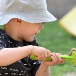 University of Washington researchers argue that greater study of infant persistence can shed light on the factors that instill this trait, and the outcomes that may emerge from it later in life. Photo of baby playing in sandbox.
