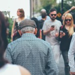 People walking in a crowd, looking at their phones.