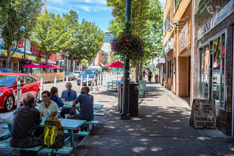 Reserved lanes for restaurants, sidewalks and tables. People are sitting at the table.