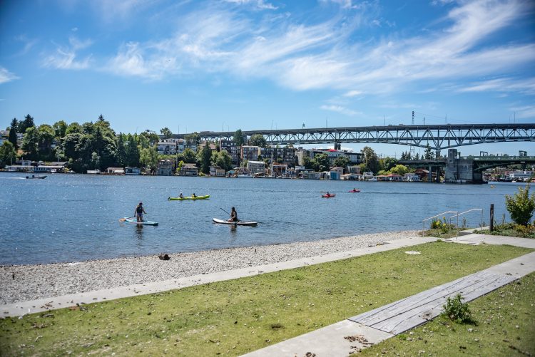 Water park with people riding stand-up paddleboards and kayaks