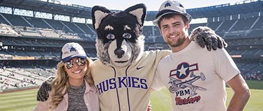 Harry Husky the mascot pictured with two fans.