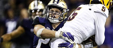 Husky football player Ben Burr-Kirven tackles an ASU player.