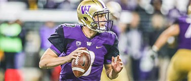 Husky quarterback Jake Browning drops backs to throw a pass.