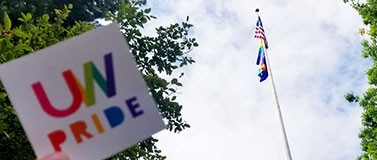 UW pride rainbow sticker with flag in background