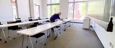 一个人在教室里清理一排课桌