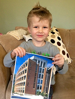 Young boy holding a photo of the Paul G. Allen Center for Computer Science & Engineering