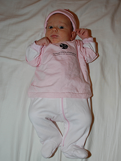Full-length shot of baby in pink outfit and hat with CSE t-shirt