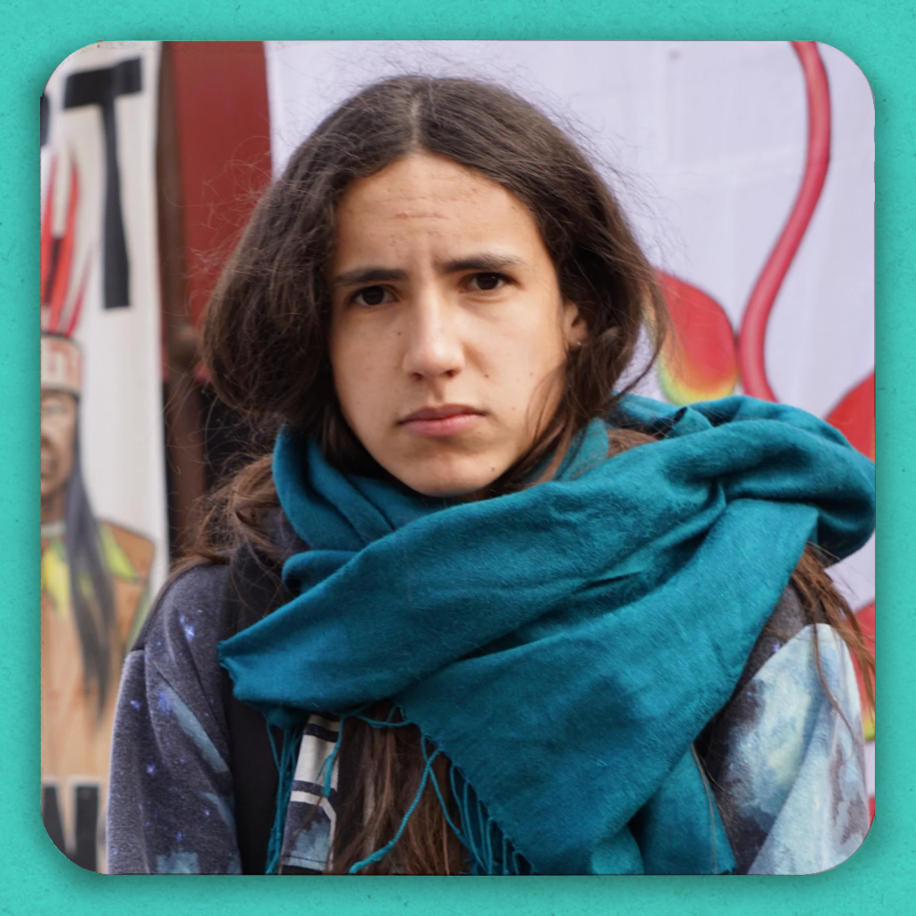 A long haired young man in a bright blue scarf