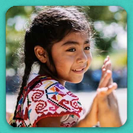 A smiling latina girl holding someone's hand.