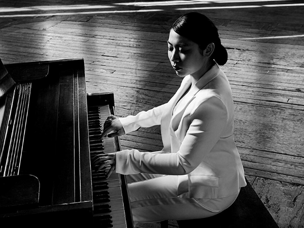 woman playing piano in white suit