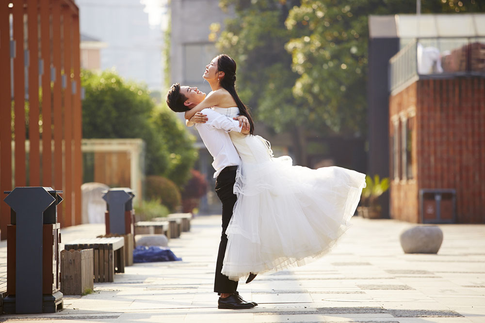 groom lifts bride in joyful embrace on wedding day