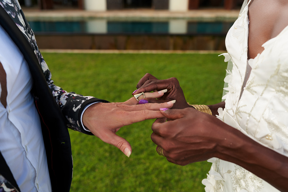 Primer plano de una pareja intercambiando un anillo de bodas en la ceremonia nupcial.
